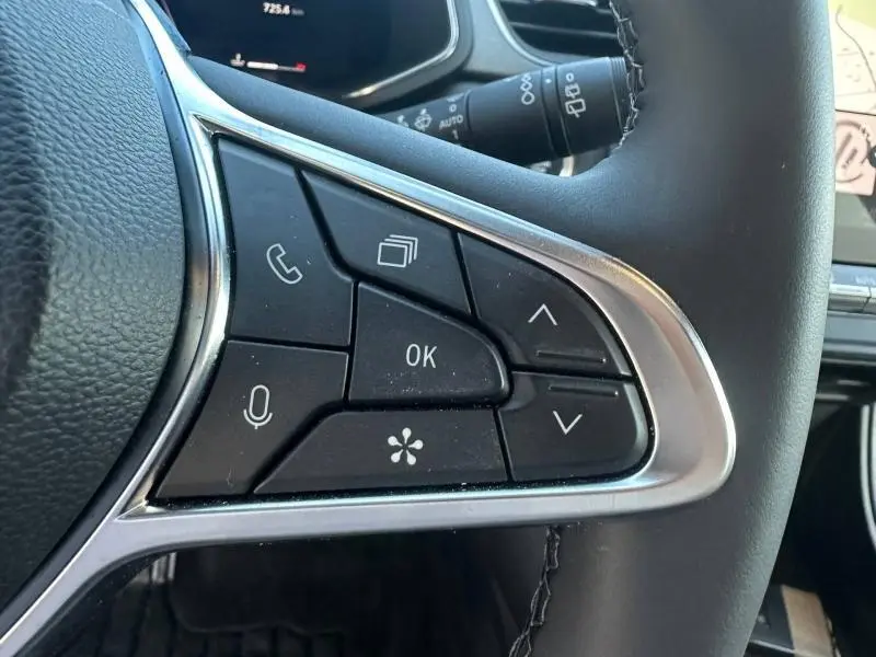 Gros plan sur les commandes multifonctions au volant du Renault Captur 2025, boutons noirs avec cadre argenté.