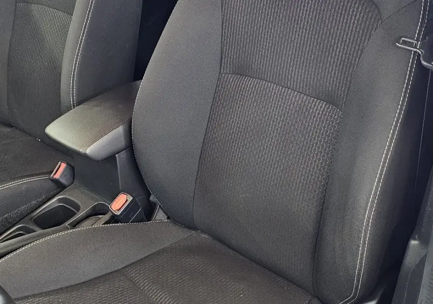 Gros plan sur les sièges avant noirs avec surpiqûres blanches de la SUZUKI SX4 S-CROSS gris 2020, côté conducteur visible.