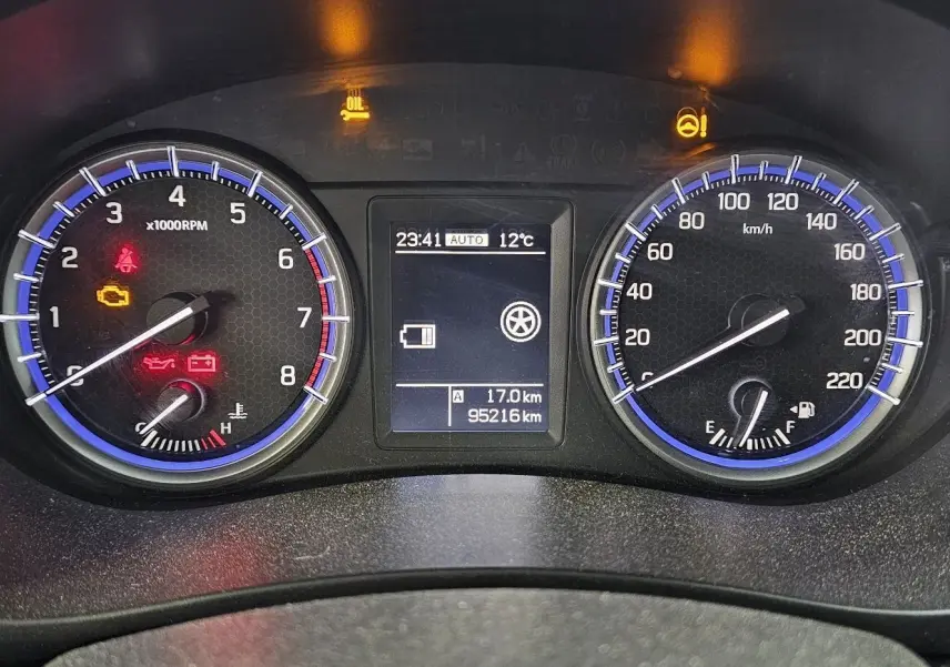 Tableau de bord du Suzuki SX4 S-Cross 2020, affichant compte-tours, vitesse, température et voyants d'alerte allumés.