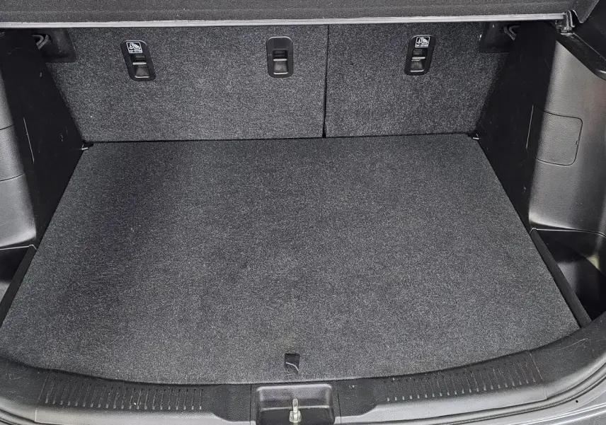 Coffre ouvert du Suzuki SX4 S-Cross gris 2020, vue intérieure montrant un espace de chargement propre et bien fini.