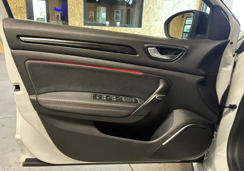 Gros plan sur la roue avant gauche noire à jante ajourée d’une Renault Mégane IV RS 280 blanche avec logo Renault Sport.