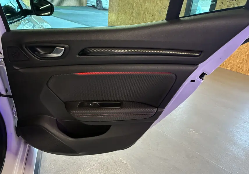 Gros plan sur le compresseur de pneu et la clé de roue dans le coffre d'une Renault Mégane IV RS 280 blanche.