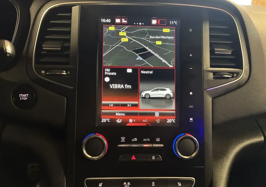 Gros plan intérieur sur le volant noir avec surpiqûres rouges et commandes audio de la Renault Mégane IV RS 280 EDC6.