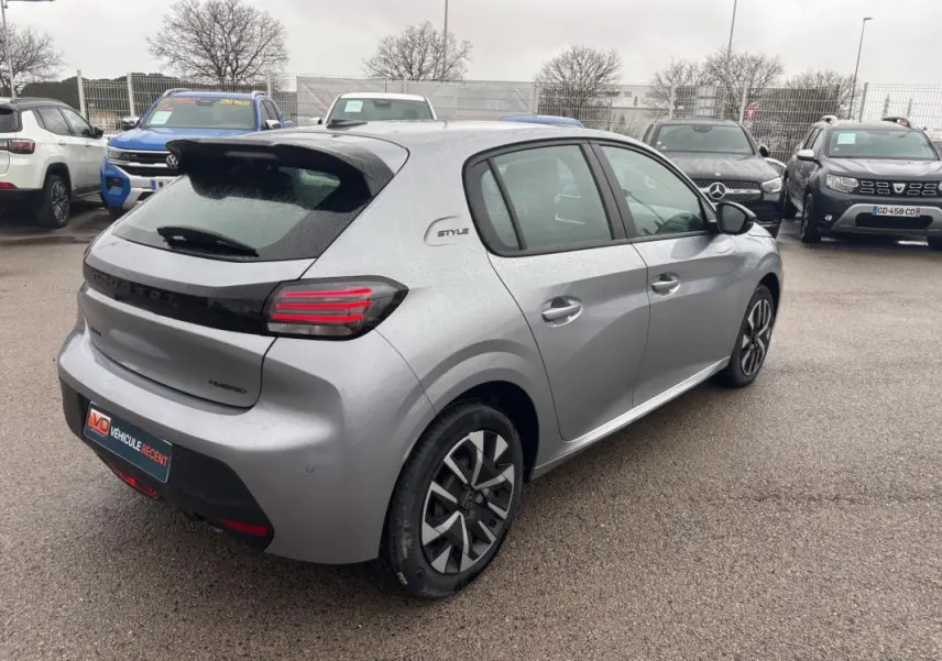 Peugeot 208 Hybrid gris vue 3/4 arrière droit, avec jantes 16 pouces et badge Style sur le côté.