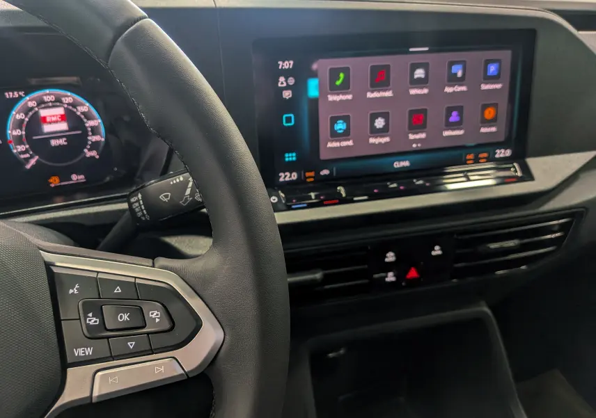 Vue intérieure du Volkswagen Caddy 2025 montrant le volant et l'écran tactile central avec interface multimédia.