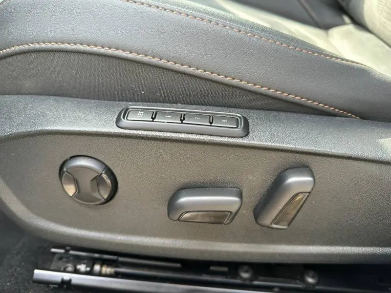 Détail des commandes de réglage électrique du siège avant en textile noir avec surpiqûres marron du CUPRA Formentor 1.5 eTSI Hybrid.