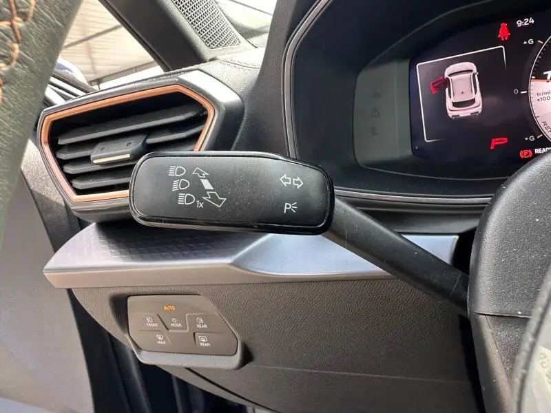 Gros plan sur la commande de clignotants à gauche du volant dans l’habitacle gris et noir du CUPRA Formentor 1.5 eTSI Hybrid 2025.