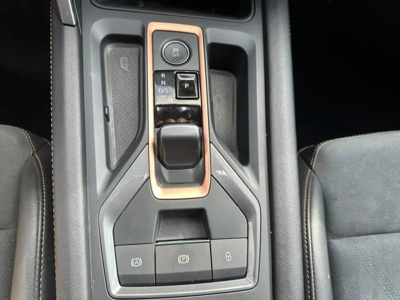 Vue plongeante sur la console centrale noire et cuivre du CUPRA Formentor 1.5 eTSI Hybrid avec commandes de boîte automatique et frein électronique.