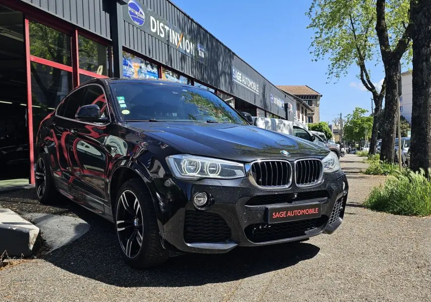 BMW X4 xDrive20dA noir en 3/4 avant droit, avec jantes sport et calandre caractéristique M Sport.