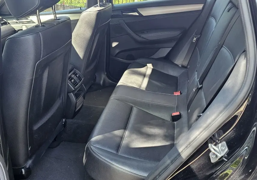 Vue intérieure côté gauche sur les sièges arrière en cuir noir du BMW X4 xDrive20dA 2015 finition M Sport.