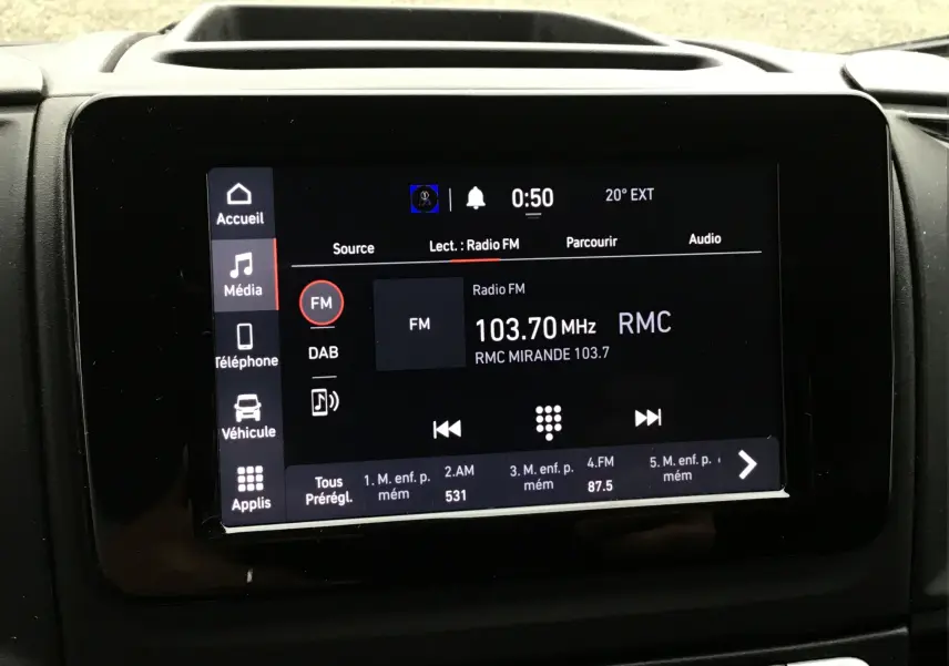 Écran tactile central du tableau de bord du Fiat Ducato blanc, affichant la radio FM sur 103.7 MHz RMC.