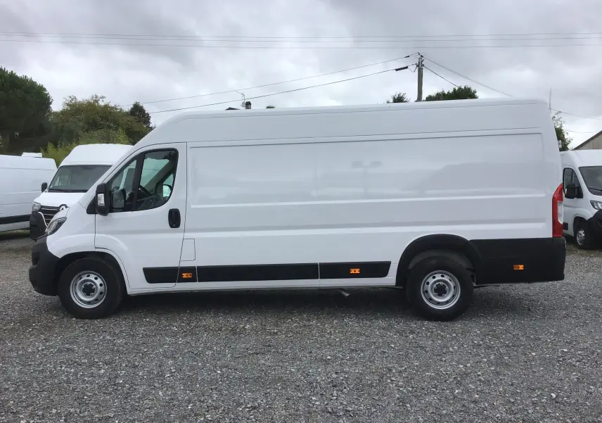Profil côté gauche d'un fourgon FIAT Ducato XLH2 blanc 2024 avec grande hauteur et marquages réfléchissants orange.