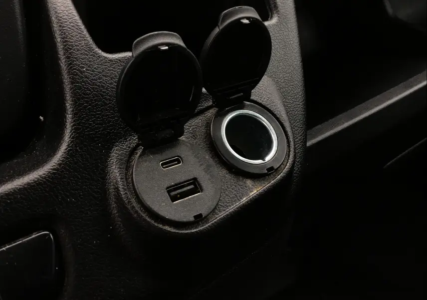 Prise USB et prise allume-cigare ouvertes dans l'habitacle noir du Fiat Ducato Fourgon XLH2 2024.