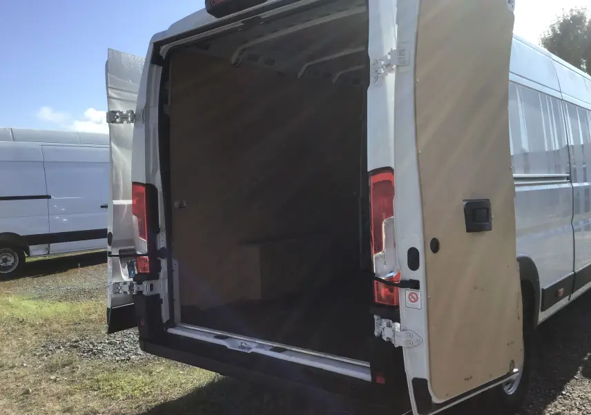Vue arrière d’un FIAT Ducato Fourgon blanc 2024 avec portes arrière ouvertes montrant l’espace de chargement vide.