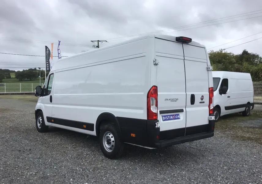 Fiat Ducato Fourgon blanc vu en 3/4 arrière droit, avec portes arrière fermées et pare-chocs noir.