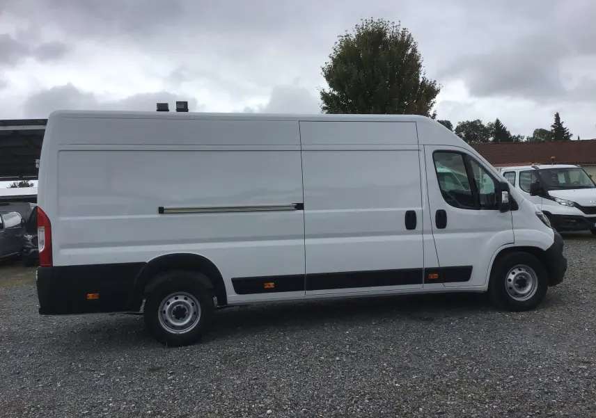 Vue de profil côté gauche d'un FIAT Ducato Fourgon blanc XLH2 3T5 avec porte coulissante et jantes acier.