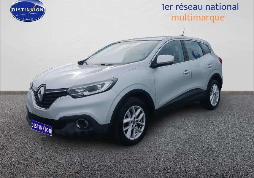 Renault Kadjar gris en 3/4 avant droit, avec jantes alu et boucliers noirs contrastants.