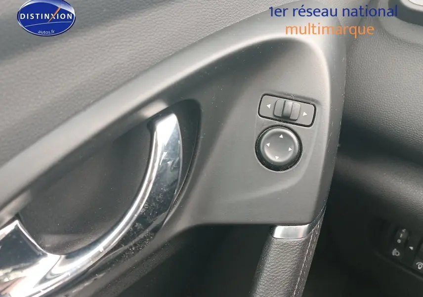 Gros plan sur la poignée de porte intérieure côté gauche du Renault Kadjar gris avec commandes de réglage des rétroviseurs.
