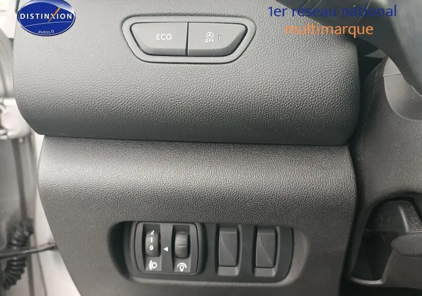 Gros plan sur les commandes Eco et arrêt auto du moteur du tableau de bord du Renault Kadjar gris 2017.