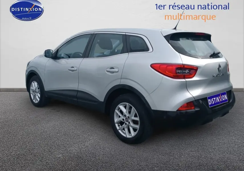 Renault Kadjar gris vu en 3/4 arrière côté gauche, avec jantes alu et feux arrière rouges distinctifs.