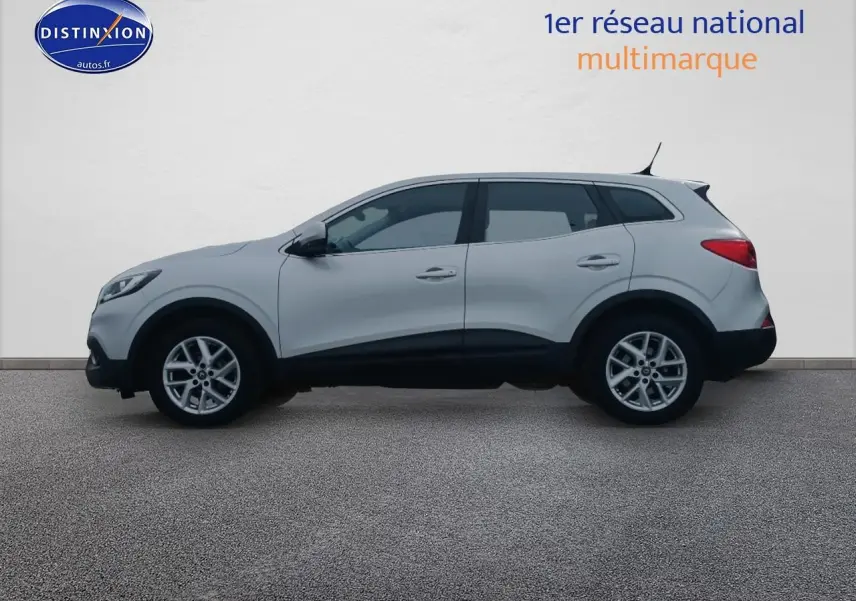 Profil côté gauche d'un Renault Kadjar gris 2017 avec jantes alu et poignées ton carrosserie sur fond neutre.
