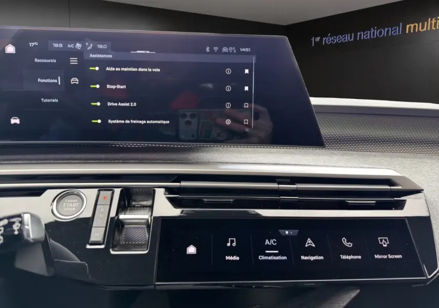 Vue rapprochée de la console centrale du Peugeot 5008 gris foncé, avec écran tactile et commandes numériques.