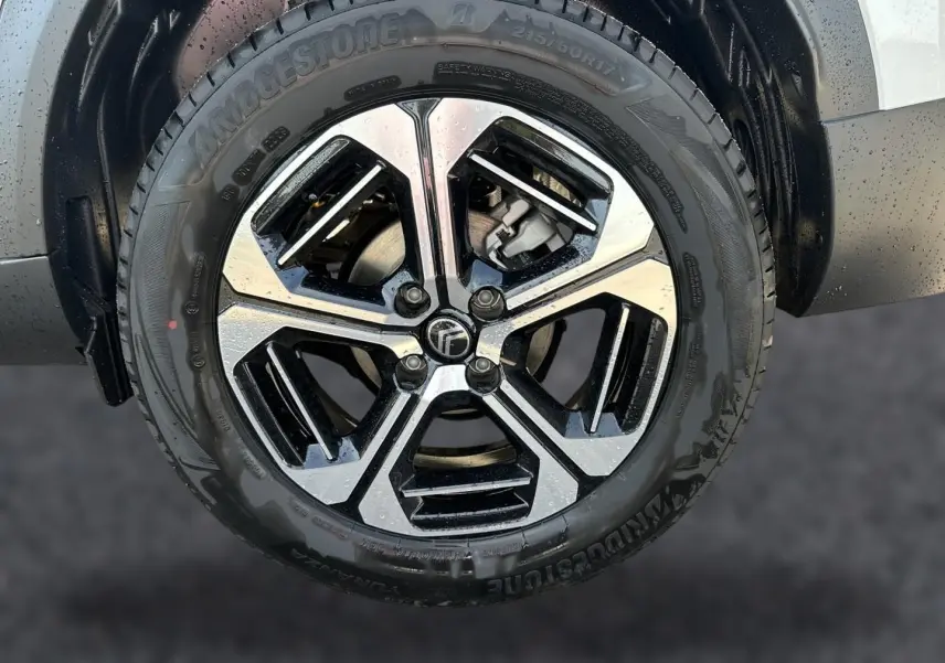 Gros plan sur la jante alliage bicolore noire et argentée du côté avant droit d’un Citroën C3 Aircross blanc.
