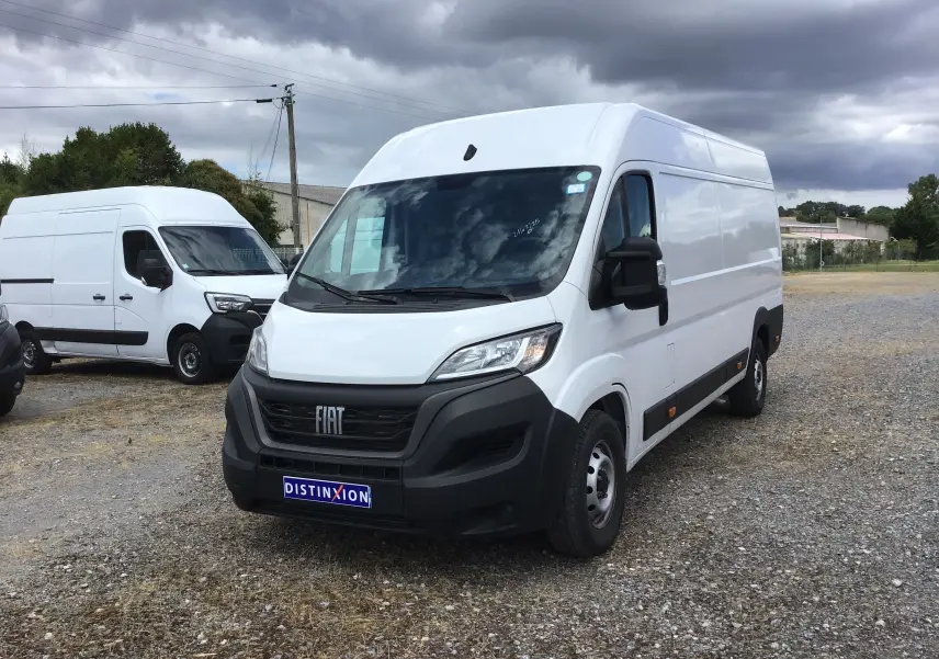 Fourgon FIAT Ducato XLH2 blanc vu de 3/4 avant droit sur un terrain extérieur sous ciel nuageux.
