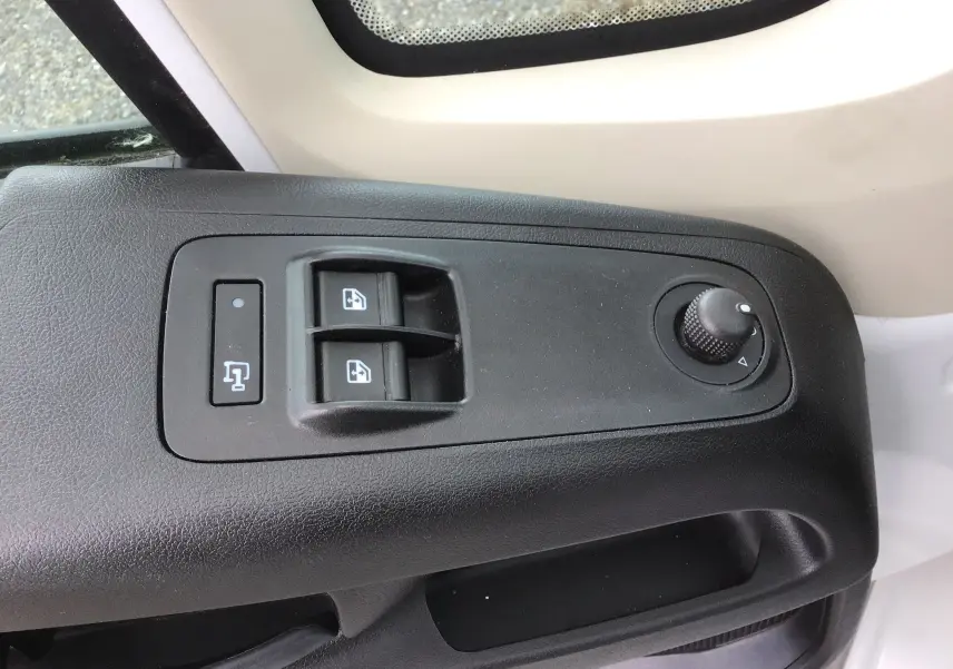 Commande des vitres électriques et réglage des rétroviseurs sur la porte côté gauche du Fiat Ducato Fourgon blanc 2024.