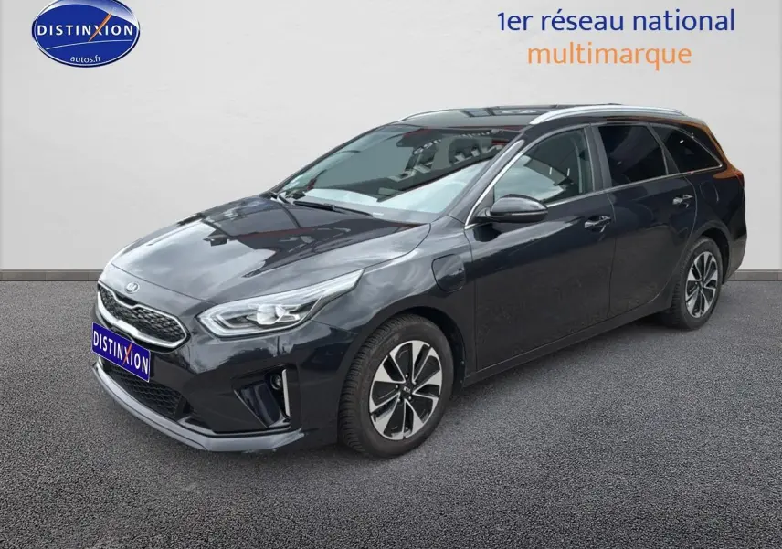 KIA CEE'D SW noire vue 3/4 avant droit, avec jantes alu et barres de toit visibles sur fond neutre.