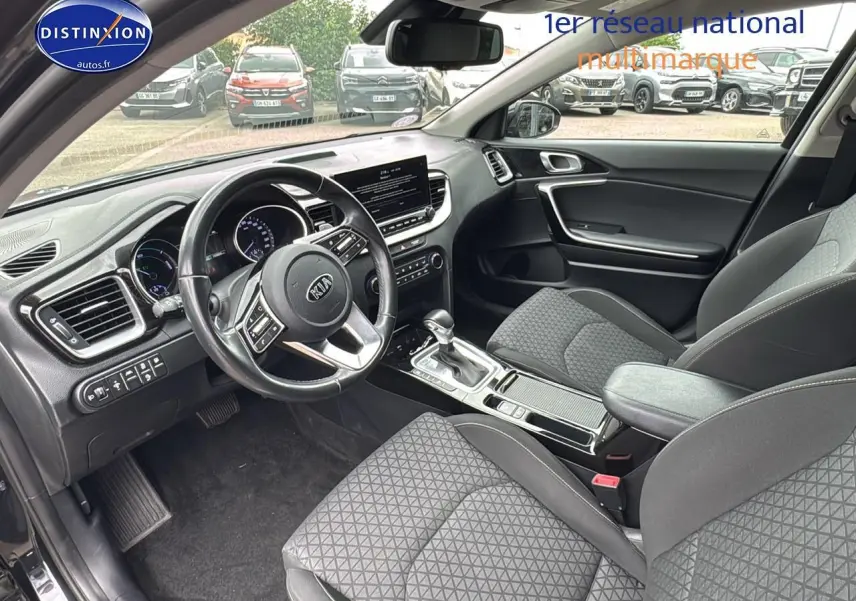 Vue intérieure côté conducteur de la Kia CEE'D SW noire 2020 avec volant cuir et console centrale moderne.