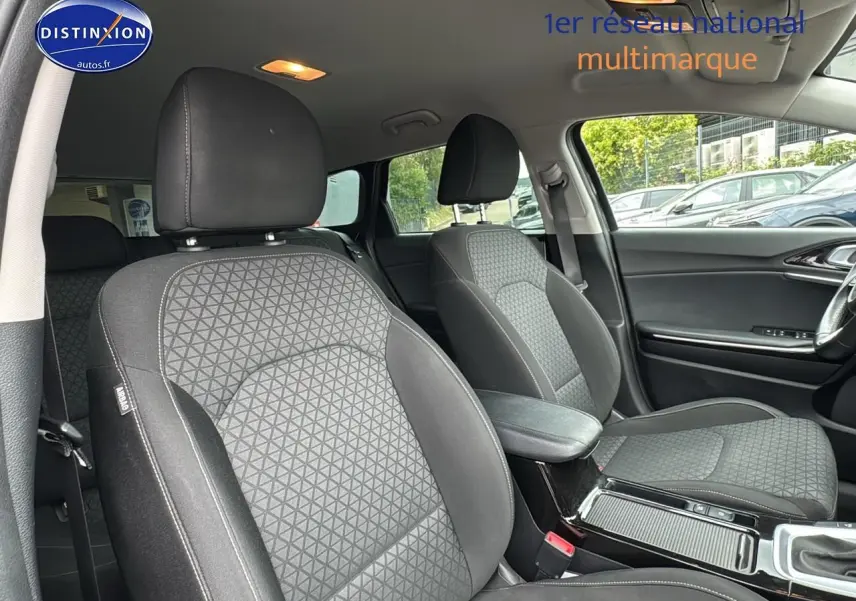 Intérieur de la KIA CEE'D SW 2020, vue côté droit sur sièges tissu noir et accoudoir central avec rangement.
