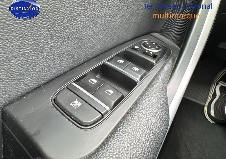 Gros plan sur les commandes des vitres électriques côté conducteur d'une Kia CEE'D SW noire de 2020.