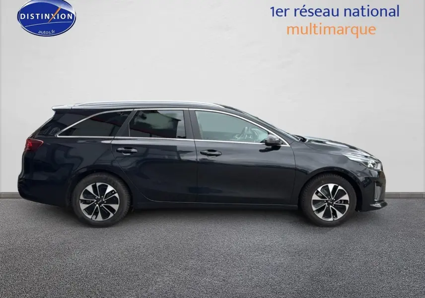 Profil côté droit d'une Kia CEE'D SW noire 2020 avec jantes alliage et barres de toit visibles.