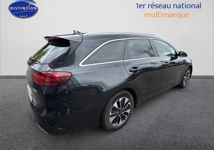 KIA CEE'D SW noire vue 3/4 arrière côté droit, avec barres de toit et feux arrière LED distinctifs.