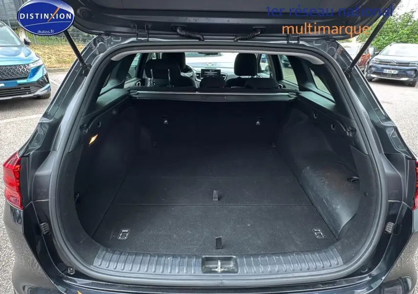 Coffre ouvert vue arrière d'une KIA CEE'D SW noire 2020, espace de chargement spacieux et intérieur sombre.