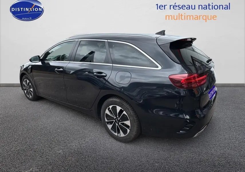 KIA CEE'D SW noir vue 3/4 arrière droit avec barres de toit et feux arrière LED allumés