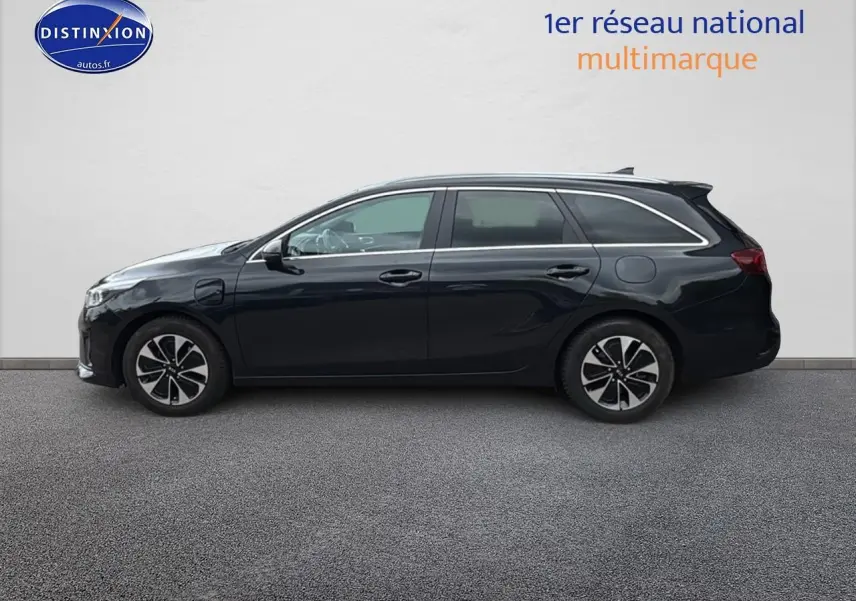 Profil côté gauche d'une Kia CEE'D SW noire 2020 avec jantes alu et barres de toit visibles.