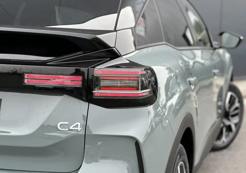 Vue arrière côté droit d'une Citroën C4 Manhattan Green avec toit noir et feux arrière LED distinctifs.