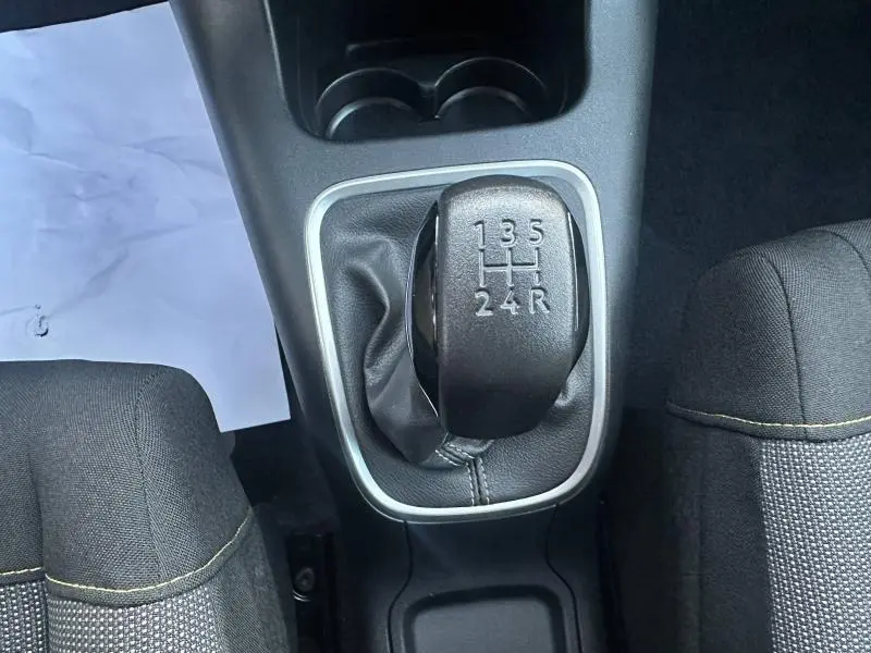 Vue rapprochée du levier de vitesses manuel noir entouré de gris dans une Citroën C3 2023, sièges tissu visibles.