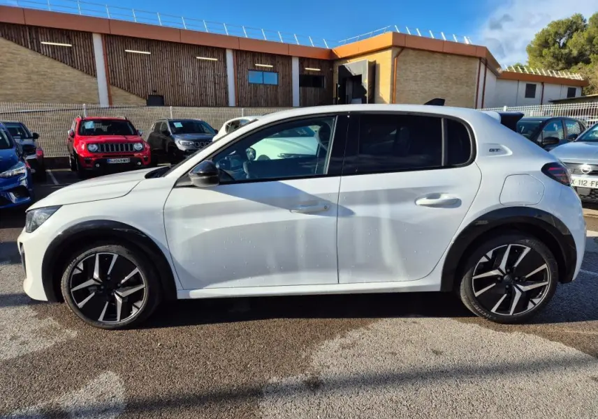 Profil droit d'une Peugeot 208 Hybrid 136 e-DCS6 GT blanche avec jantes alliage 17 pouces et vitres teintées.