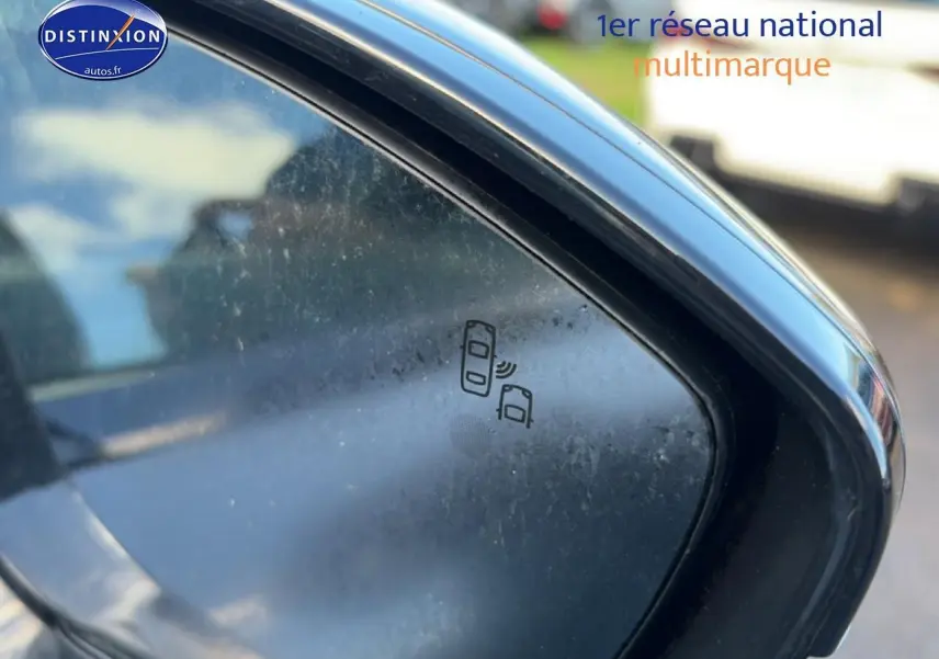 Gros plan sur le rétroviseur droit noir du Peugeot 508 Hybrid gris titane, avec icône d'alerte angle mort visible.