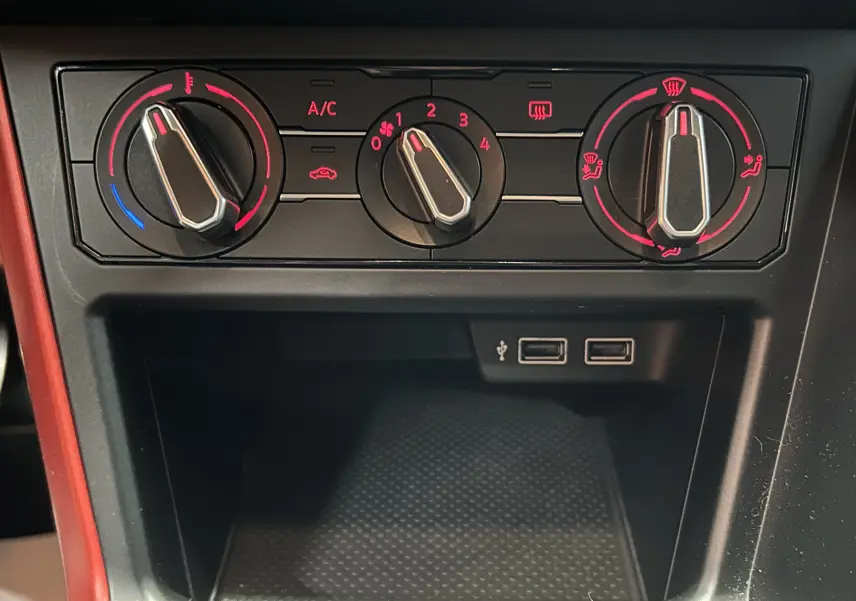 Gros plan sur les commandes de climatisation et deux ports USB du tableau de bord d'une Volkswagen Polo gris.
