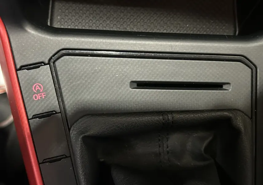 Gros plan sur la console centrale de la Volkswagen Polo grise, mettant en valeur le soufflet de levier de vitesse et le bouton arrêt auto start/stop.