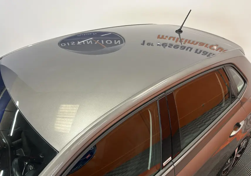 Vue plongeante côté gauche sur une Volkswagen Polo gris métallisé avec vitres teintées et antenne de toit.