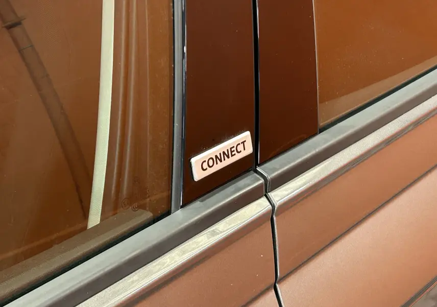 Gros plan sur l’écusson "CONNECT" sur la partie centrale noire entre les vitres d’une Volkswagen Polo gris métallisé.