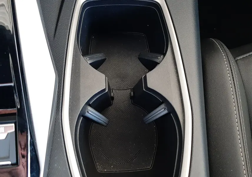 Gros plan sur les porte-gobelets centraux noirs avec contour argenté dans l’habitacle du Peugeot 5008 Hybrid 2025.