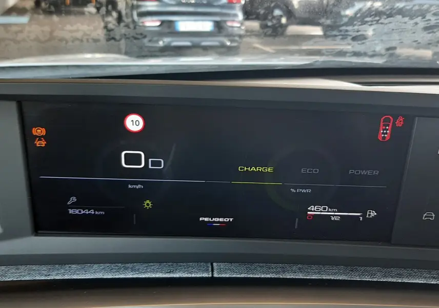 Vue intérieure du tableau de bord numérique du Peugeot 5008 Hybrid 145ch, affichant l'autonomie et les alertes de conduite.