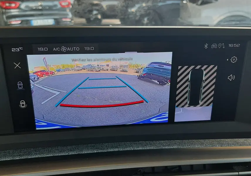 Vue écran multimédia du Peugeot 5008 blanc Okenite montrant la caméra de recul avec lignes de guidage et vue 360° stationnement.