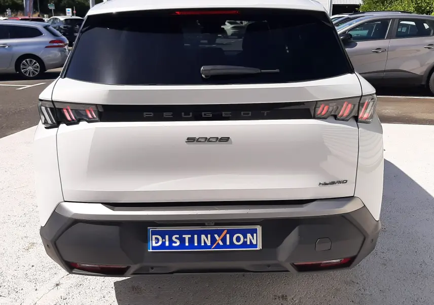 Vue arrière d’un Peugeot 5008 blanc Okenite hybride 2025 avec feux LED caractéristiques et logo distinctif.